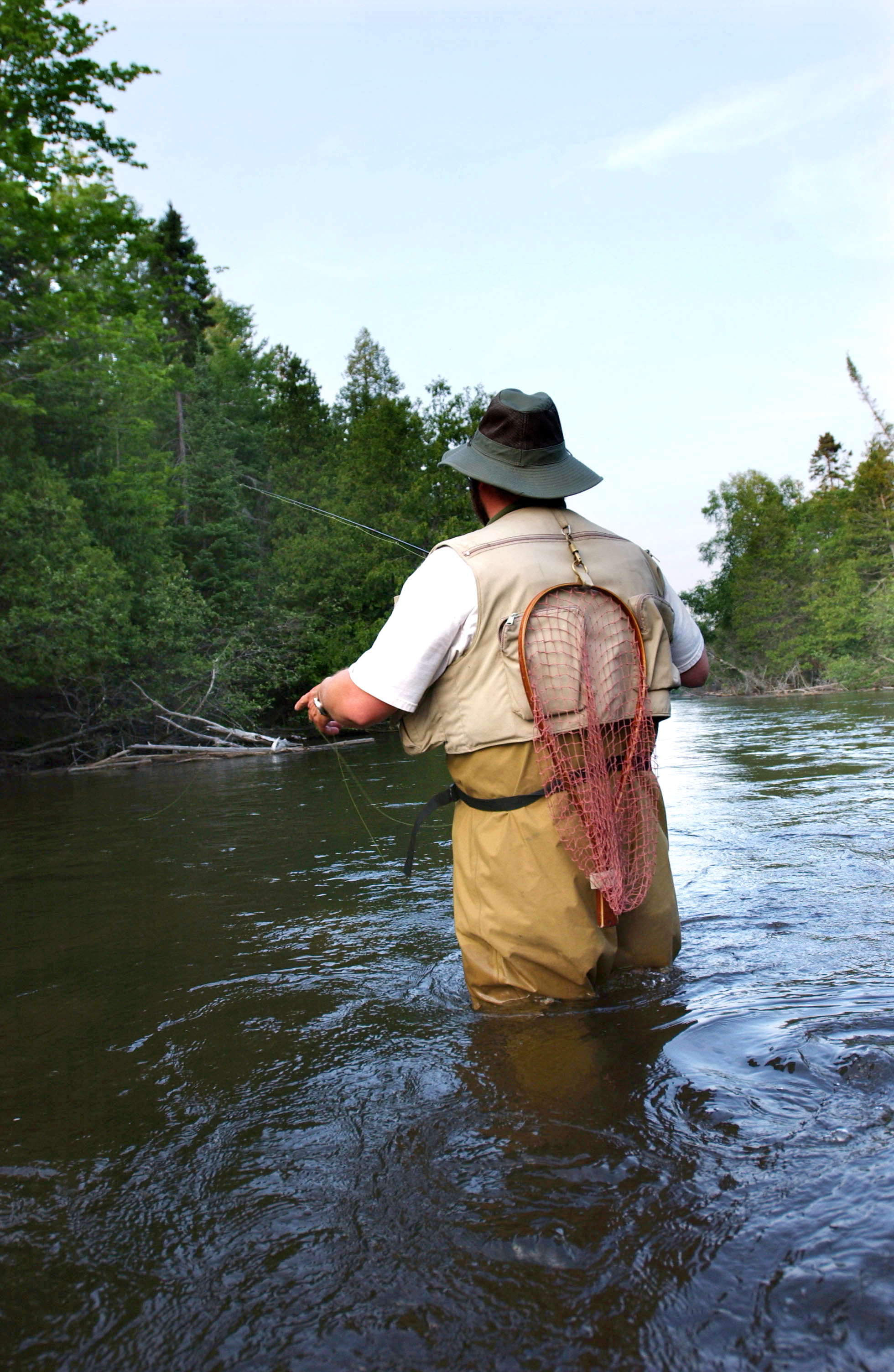 picture of a man standing in the river fishing